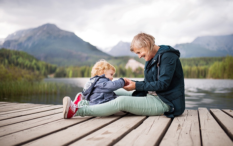grandma-and-granddaughter-sitting-lakeside