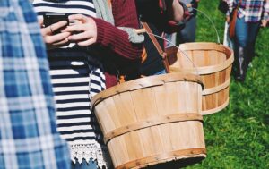 teens holding apple baskets with cellphone