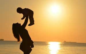 silhouette of mom and baby at beach